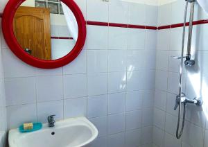 baño con espejo rojo y lavabo en Jardin des sucriers 2, en Trois-Rivières