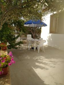 een tafel en stoelen met een blauwe parasol bij E case tu Bertu in Marina di Mancaversa