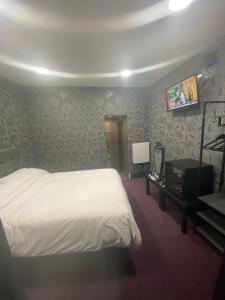 um quarto com uma cama e uma mesa com uma televisão em Mannbuilding em Londres