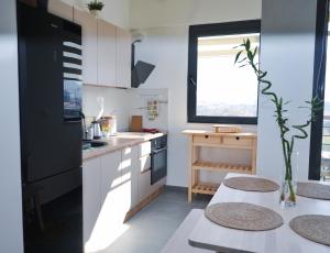 uma cozinha com um frigorífico preto e uma mesa em Sunlight Apartment em Skopje