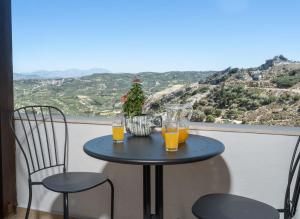 una mesa con 2 vasos de zumo de naranja en el balcón en Krouson Mansion en Krousón