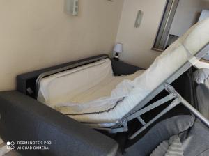 een leeg ziekenhuisbed in een kamer met een bank bij LE BARCARES in Le Barcarès