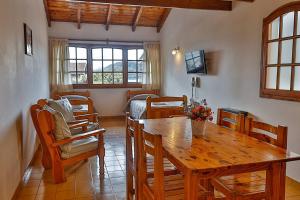 1 dormitorio y sala de estar con mesa de madera. en LA PONDEROSA Apart Hotel en San Carlos de Bariloche