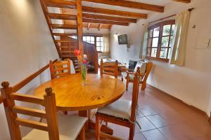a dining room with a wooden table and chairs at LA PONDEROSA Apart Hotel in San Carlos de Bariloche