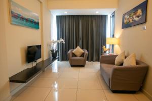 a living room with two chairs and a television at Sky Hotel in Kota Kinabalu
