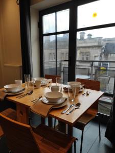 a wooden table with plates and silverware on it at City Centre 2 bedrooms 2 Ensuite Flat free parking in Nottingham