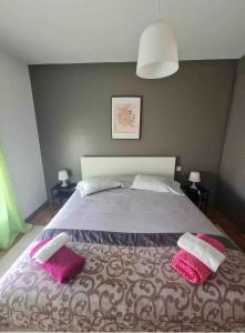una camera da letto con un grande letto con due cuscini rosa di Apartamento Francelos Condominio a Vila Nova de Gaia