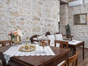 comedor con mesa, sillas y pared de piedra en Krouson Mansion en Krousón