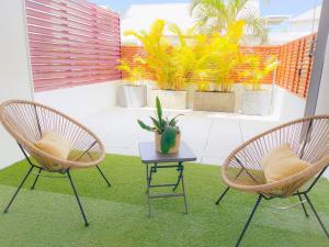 2 chaises et une table sur un balcon avec des plantes dans l'établissement zen attitude, à Saint-Denis