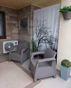 un patio con 2 sillas y aire acondicionado en Gyógyvölgy apartman, en Egerszalók