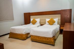dos camas sentadas una al lado de la otra en una habitación en أنوار نجد للشقق الفندقية en Riad