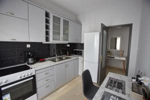una cucina con armadietti bianchi e frigorifero bianco di C.L.A. 2 City Lux Apartment Alaxandroupoli a Alexandroupoli