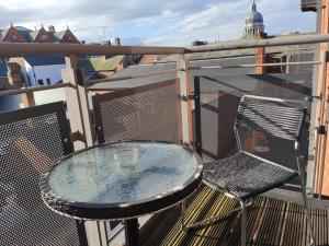 una mesa de cristal y una silla en un balcón con vistas en City Centre 2 bedrooms 2 Ensuite Flat free parking en Nottingham