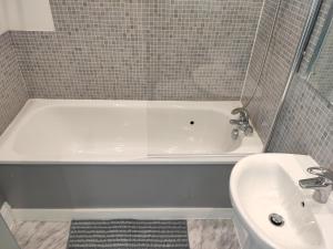 a bathroom with a white tub and a sink at City Centre 2 bedrooms 2 Ensuite Flat free parking in Nottingham +33 photos