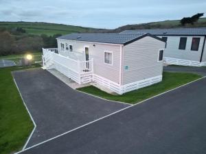 a large white house with a parking lot at 3-Bedroom Holiday Home with Valley Views in Newquay