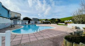 a large swimming pool in a yard with a patio at 3-Bedroom Holiday Home with Valley Views in Newquay