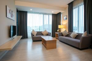 ein Wohnzimmer mit 2 Sofas und einem TV in der Unterkunft Sky Hotel in Kota Kinabalu
