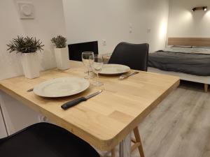 a wooden table with two plates and wine glasses at Le Villarois in Nancy