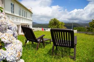 dos sillas y un banco en un patio con flores en Beachfront Surf & Remote Work House, en Valdoviño