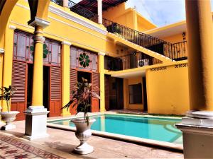 a building with a swimming pool in front of a building at Hotel Real Toledo by Kavia in Mérida