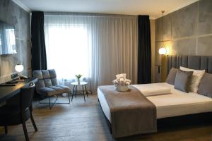 um quarto de hotel com uma cama e uma cadeira e uma janela em Hotel Zum Weissen Ross em Delitzsch