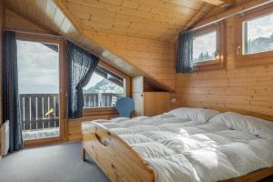 una camera da letto con letto in una camera in legno con finestre di Tschiffra OG a Bettmeralp