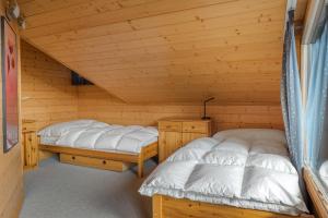 two beds in a log cabin with at Tschiffra OG in Bettmeralp