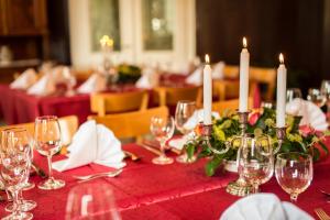 una mesa con copas de vino y velas blancas. en Hotel Leyscher Hof, en Leutesdorf