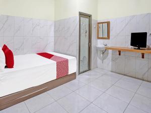 蘇達約縣的住宿－OYO Life 91884 Kost Kusuma Dewi Syariah，一间卧室配有一张床,浴室配有电视。