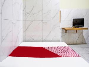 Habitación con cama con alfombra roja en OYO Life 91884 Kost Kusuma Dewi Syariah, en Sidoarjo