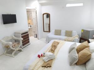 biały pokój z łóżkiem i telewizorem w obiekcie Casa Ego w mieście Cartagena de Indias