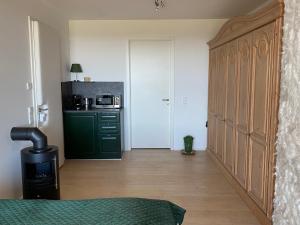 a kitchen with a green cabinet and a microwave at ALPEN-PANORAMA SUITE - Einzigartige Privatsuite hoch über München, 12tes OG, Alpenblick, Loggia, Whirlpool, 15 Minuten zum Zentrum, Ruhe und Erholung in der Stadt München für privat und geschäftlich Reisende in Munich +22 photos