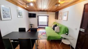 a living room with a green couch and a table at Casa em Alfama in Lisbon