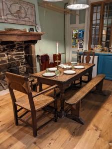 una mesa de madera con 2 sillas y una vela. en House of secrets en Morlaix