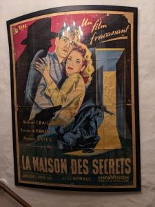 un poster de una pelicula de un hombre y una mujer en una pared en House of secrets, en Morlaix