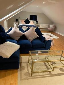 sala de estar con sofá azul y mesa de cristal en The Pheasantry - guest house in beautiful rural location, en Aldermaston