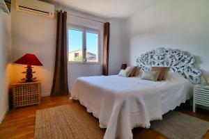 a bedroom with a white bed and a window at La Dolce Villa 11 persones Private Pool beautiful Landscaped Garden in Mandelieu-La Napoule