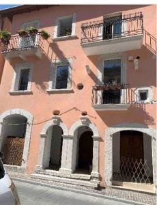 a pink building with balconies on a street at A casa di Rocco in Castel di Sangro