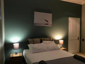 1 dormitorio con 1 cama con pared verde en Aluve Guesthouse en Johannesburgo