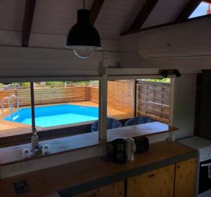 a kitchen with a view of a swimming pool at La tiny de titanse avec piscine in Cadet