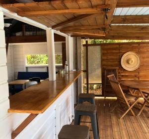 a kitchen with a bar and chairs in a cabin at La tiny de titanse avec piscine in Cadet