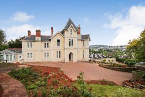 a large white house with a large driveway at Torbay Rise sea side villa with family facilities in Torquay