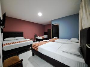 a hotel room with two beds and a tv at Hotel 9-25 in Pereira