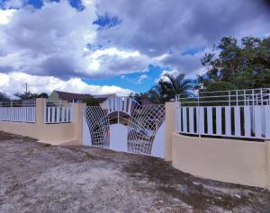 a white fence in front of a house at Gables Vacation Rentals with Private Gated Parking Onsite in Knockpatrick