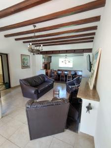 a living room with leather couches and a dining room at Apart Hotel Naga Huel in Sierra de la Ventana