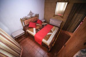 a bedroom with a wooden bed with red sheets at Club JM Lanzarote in Tabayesco