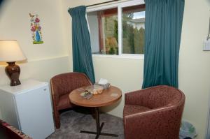 a room with two chairs and a table and a window at Guest Suite Private Retreat- Honeymoon Suite- J-1 in Abbotsford