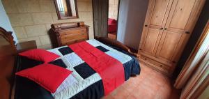 a bedroom with a bed with a red and blue quilt at Club JM Lanzarote in Tabayesco