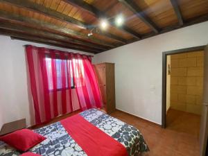 a bedroom with a bed and a red curtain at Club JM Lanzarote in Tabayesco