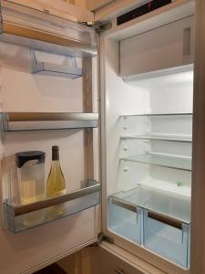 an open refrigerator with a bottle of wine in it at V&V CENTRE Neuchatel in Neuchâtel